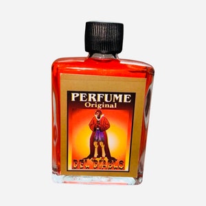 May include: A small glass bottle of red liquid with a black cap. The label reads "PERFUME Original DEL DIABLO" and features an illustration of a devil in a red robe.