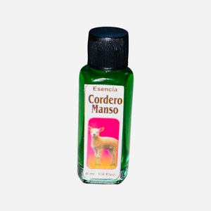 May include: A small green glass bottle with a black cap. The label reads "Esencia Cordero Manso" and features a white lamb on a pink background. The bottle contains 8 ml or 1/4 fl oz of liquid.