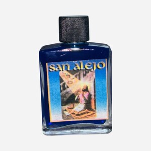 May include: A small, clear glass bottle filled with a deep blue liquid. The bottle has a black cap and a label with the words "San Alejo" and an image of a religious figure. The label has a blue and yellow border.
