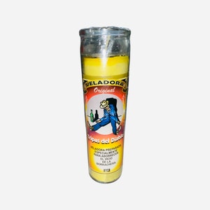 May include: Yellow candle with a picture of a man passed out with a bottle of alcohol. The text on the candle reads "Veladora Original Tripas del Diablo Veladora preparada especialmente para aborrece el vicio de la borrachera."