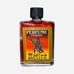 May include: A small, rectangular perfume bottle filled with a red liquid. The label reads "PERFUME Original" above an illustration of a sword and ribbons. The word "Retiro" is printed in a decorative font below the illustration. The bottle has a black cap.