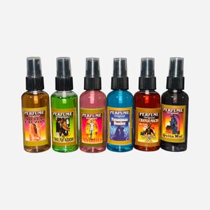 Puede incluir: Seis peque&ntilde;as botellas de spray con etiquetas coloridas y tapas negras. Las etiquetas tienen la palabra "PERFUME" y varias palabras en espa&ntilde;ol, incluyendo "Quita Calzon", "Triunfador", "Afrodita", "Feromonas Hombre", "Chango Macho" y "Quita Mal".