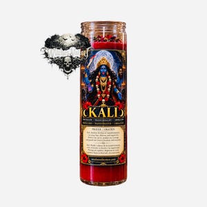 Puede incluir: Una vela cilíndrica alta de vidrio llena de cera roja, con una etiqueta que muestra una ilustración de la deidad Kali, el texto KALI, PROTECCIÓN TRANSFORMACIÓN LIBERACIÓN y una oración en inglés y español, cubierta con pétalos de flores rojas secas.