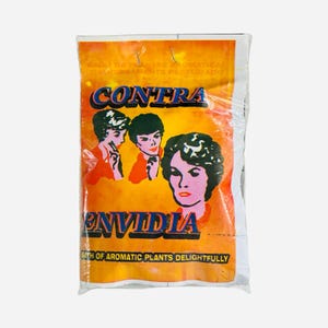 May include: A clear plastic bag with an orange and white label. The label features the word "CONTRA" above the word "ENVIDIA" in blue. The label also has illustrations of three women and text that reads "BATH OF AROMATIC PLANTS DELIGHTFULLY".