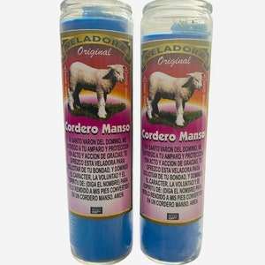 Puede incluir: Dos frascos de vidrio azul para velas con etiquetas blancas. Las etiquetas tienen el texto "VELADORA Original" y "Cordero Manso". Las etiquetas también muestran una imagen de un cordero blanco. El texto en las etiquetas está en español.