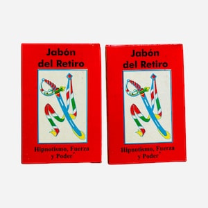 May include: Two rectangular red soap boxes labeled Jabón del Retiro with the text Hipnotismo, Fuerza y Poder. Each box features a central white square containing a graphic illustration of a blue sword with a red and green ribbon wrapped around it.