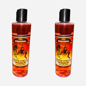 May include: Two bottles of red liquid with a black label that says "ORIGINAL" and "DOMINA TODO" with a bull rider graphic.