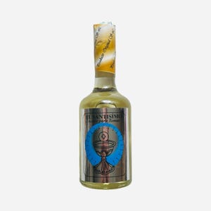 May include: A clear glass bottle with a gold label that reads "El Santisimo Aceite para Tomar". The label also features a silver chalice with a blue background and a cross.