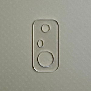 May include: A close-up of a clear plastic phone case with three cut-out circles for the camera lenses.