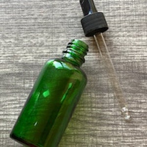 Peut inclure: Une bouteille en verre vert avec un bouchon compte-gouttes noir. La bouteille est vide et le compte-gouttes est s&eacute;par&eacute;.