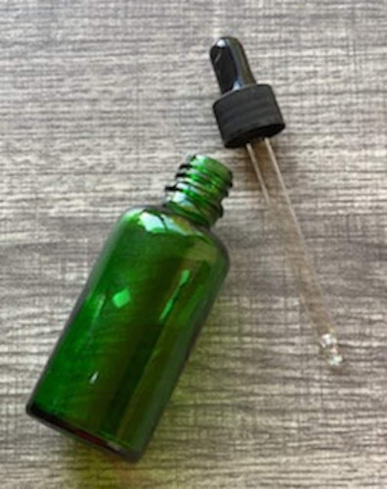 Peut inclure: Une bouteille en verre vert avec un bouchon compte-gouttes noir. La bouteille est vide et le compte-gouttes est s&eacute;par&eacute;.