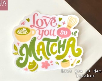 May include: A die-cut sticker featuring the text Love you so MATCHA in pink and green script. The design includes illustrations of a yellow matcha latte, a bamboo whisk, a green macaron, a small bowl of matcha powder, and pink cherry blossoms.