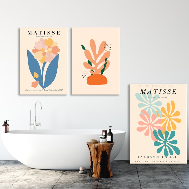 May include: Three colorful abstract art prints featuring cut paper designs by Henri Matisse. The prints are titled "Matisse, Papiers Decoupes" and feature a flower, a coral-like plant, and a cluster of flowers. The prints are framed and hung on a white wall.