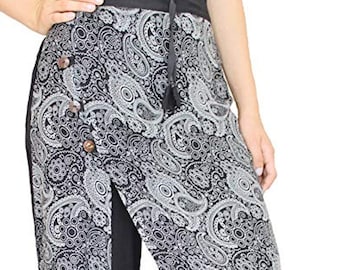 May include: Black palazzo pants with a decorative overlay featuring a white paisley pattern. The overlay is secured with buttons and a drawstring. The pants are wide-legged and suitable for casual wear.