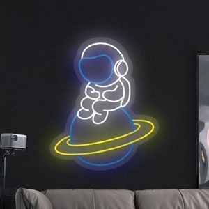 Astronaut Spaceman Sitting On Planet Neon Sign