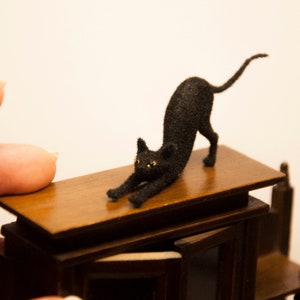 ドールハウスの猫。1/12スケールのドールハウスやジオラマにぴったりの、伸びる職人技のペットです。ふわふわの黒い子猫のおもちゃです。