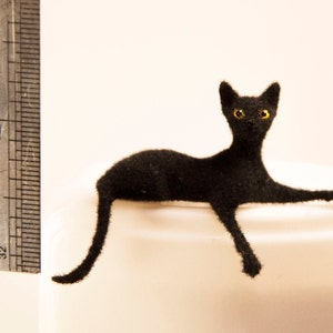 Miniature cat, lying down artisan pet in 1:12 twelfth scale for doll house of diorama. Fluffy black kitten toy