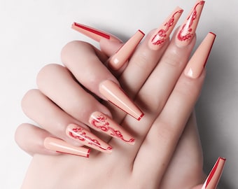 May include: Long, nude-coloured, false nails with a red accent line and a red dragon design. SM14210455