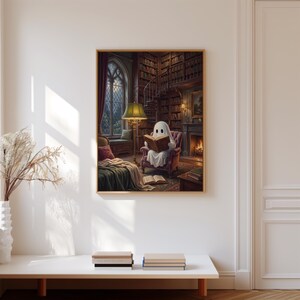 Puede incluir: Una impresi&oacute;n de arte mural enmarcada que representa una figura de fantasma blanca sentada en un sill&oacute;n de felpa dentro de una biblioteca oscura, leyendo un libro abierto. La escena incluye una l&aacute;mpara de pie, una chimenea con fuego y estanter&iacute;as.
