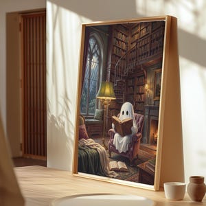 Puede incluir: Una impresi&oacute;n de arte mural rectangular enmarcada que representa una figura de fantasma blanca sentada en un sill&oacute;n morado leyendo un libro dentro de una biblioteca. La escena incluye una l&aacute;mpara de pie, una chimenea, estanter&iacute;as y un ventanal.