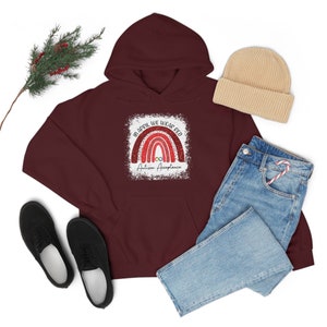 May include: A maroon hoodie with a white graphic of a rainbow with the text "In April We Wear Red Autism Acceptance".