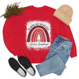 May include: Red sweatshirt with a rainbow design and the text "In April We Wear Red Autism Acceptance".