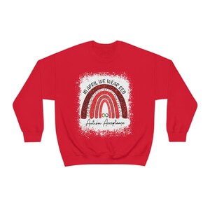 May include: Red sweatshirt with a white graphic of a rainbow with the text "In April We Wear Red" and "Autism Acceptance" below the rainbow.