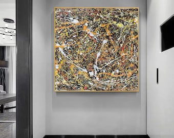 May include: Abstract painting with a black background and splashes of yellow, orange, white, and red paint. The painting is framed in a gold frame.