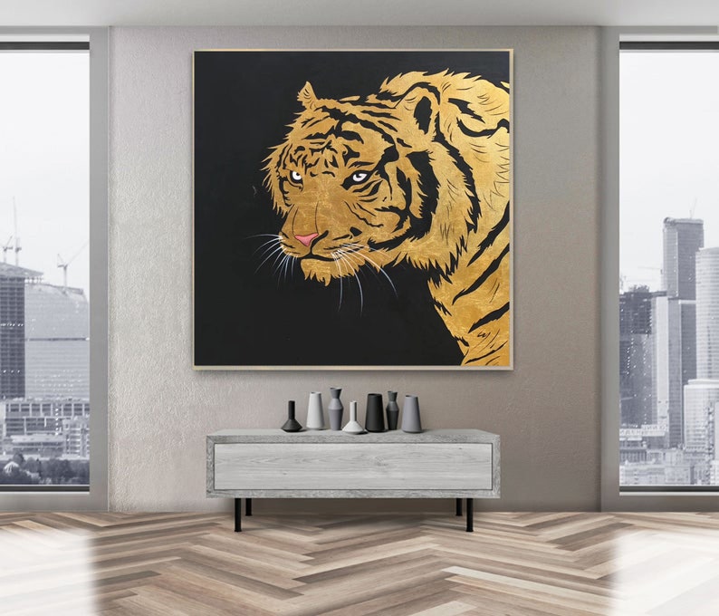 May include: A close-up of a golden tiger's face against a black background. The tiger's fur is detailed with gold paint and its eyes are a deep brown.