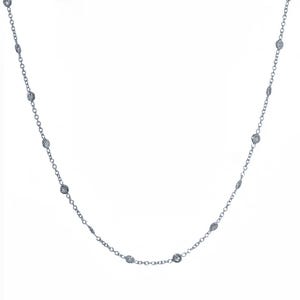 May include: A delicate silver necklace featuring a series of small, round, clear gemstones evenly spaced along a fine chain. The gemstones appear to be set in a bezel setting, and the necklace is displayed against a white background.