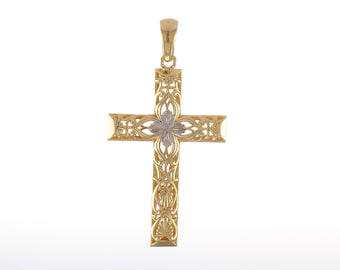 Może przedstawiać: Złoty wisiorek w kształcie krzyża z misternymi wzorami kwiatowymi. Środek krzyża zdobi mniejszy biały krzyż.