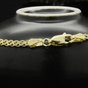 May include: A gold chain necklace with a lobster clasp closure. The chain is made of small, interlocking links.