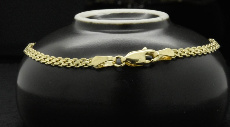 May include: A gold chain necklace with a lobster clasp closure. The chain is made of small, interlocking links.