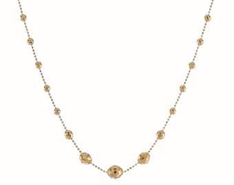 Op de afbeelding: Een gouden ketting met een ketting en ronde kralen. De kralen zijn getextureerd en hebben een gehamerde afwerking.