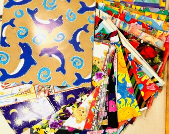 Puede incluir: Una colección de papel de regalo colorido con varios diseños, incluyendo delfines, flores, estrellas y la palabra "Happy".