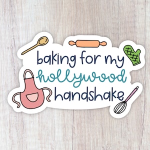 May include: A white sticker with the text "baking for my hollywood handshake" in blue and teal lettering. The sticker features a pink apron, a wooden spoon, a rolling pin, a green oven mitt, and a pink whisk.