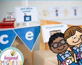 Op de afbeelding: Een speelcentrum ingericht als postkantoor met een balie, een groot pakket en twee kinderen verkleed als postbode. Het bord boven de balie staat "post office counter". Het bord op het pakket staat "large package".