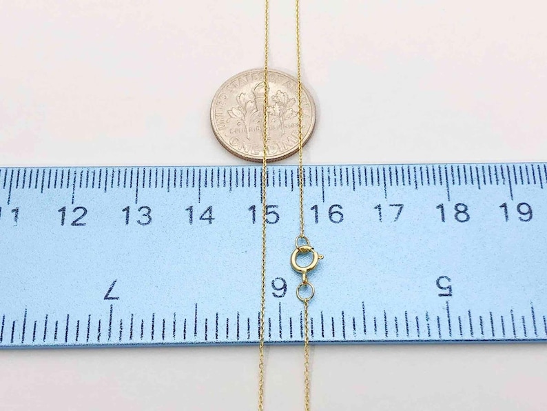 K&ouml;nnte beinhalten: Eine goldene Kettenkette mit einer L&auml;nge von 19 Zoll. Die Kette ist neben einem Lineal und einem US-Penny zur Skalierung abgebildet.