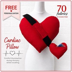 May include: A red heart-shaped pillow with a black strap, displayed on a white mannequin. The text reads FREE PERSONALISATION, 70 fabrics TO CHOOSE FROM, Cardiac Pillow, and Comfort & protection during recovery whilst travelling.