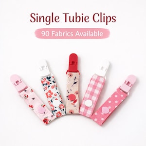 May include: Five fabric clips with white plastic clips and pink, red, and floral patterns. The text "Single Tubie Clips" and "90 Fabrics Available" are displayed in the image.
