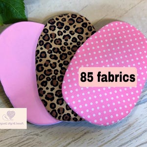 May include: Three oval fabric swatches: solid pink, leopard print, and pink with white polka dots. The polka dot swatch has a label that reads "85 fabrics". The image is of fabric samples.