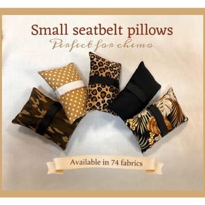 Puede incluir: Pequeños cojines para cinturón de seguridad en varios patrones, incluyendo camuflaje, estampado de leopardo y diseños florales. Cada cojín tiene una correa negra y está diseñado para la comodidad. El texto dice "Pequeños cojines para cinturón de seguridad" y "Disponible en 74 tejidos."