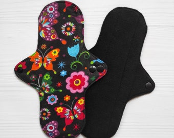 Blocs en tissu noir avec des papillons et des fleurs. Protège-slips réutilisables en coton. Serviettes hygiéniques biologiques.