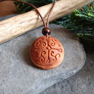 Celtic pattern pendant carved in avocado seed. Triskele and Celtic cross pendant. Pagan celtic amulet. Hand carved pendant on leather cord.