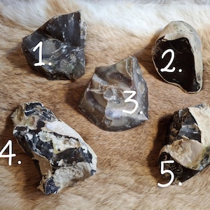 Puede incluir: Cinco piedras de sílex diferentes, cada una con una forma y un patrón únicos. Las piedras están numeradas del 1 al 5.