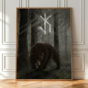 Könnte beinhalten: Gerahmter Kunstdruck mit einem braunen Bären in einer dunklen Waldszene. Über dem Bären ist ein weißes Symbol zu sehen. Das Kunstwerk hat eine gedämpfte Farbpalette, wobei der Bär im Mittelpunkt steht.