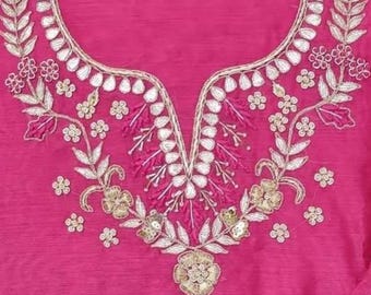 May include: A vibrant fuchsia-colored garment with intricate embroidery. The neckline and bodice feature detailed floral and leaf patterns in gold and silver thread, creating a luxurious look. The fabric has a subtle sheen.