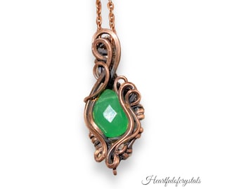 May include: A green gemstone pendant with a copper wire wrap design. The pendant is hanging from a copper chain.
