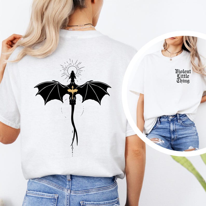 May include: White t-shirts with black graphic designs. One shirt features a dragon with outstretched wings and a sunburst design. The other shirt has the text "Violent Little Thing" in a gothic font.