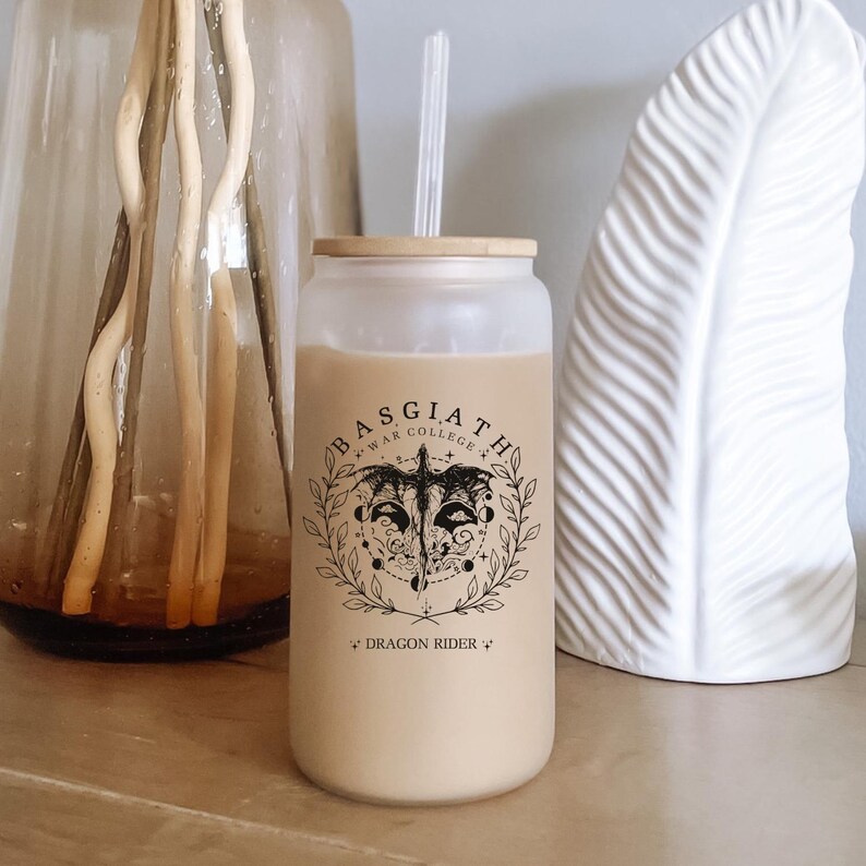 May include: A white reusable tumbler with a black and white graphic of a dragon with the text "Basgiath War College" and "Dragon Rider" printed on the side.
